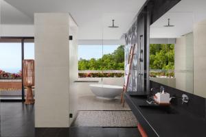 a bathroom with a white tub and a sink at Renaissance Bali Uluwatu Resort & Spa in Uluwatu