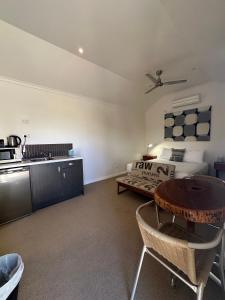 un soggiorno con tavolo e cucina di Parachilna Overflow Accommodation a Flinders Ranges