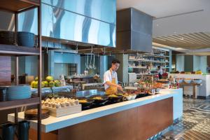 a man standing in a kitchen preparing food at Renaissance Bali Uluwatu Resort & Spa in Uluwatu