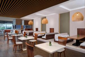 a restaurant with tables and chairs and a cafeteria at Renaissance Bali Uluwatu Resort & Spa in Uluwatu