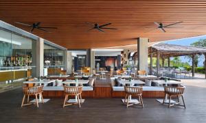 a restaurant with tables and chairs and a bar at Renaissance Bali Uluwatu Resort & Spa in Uluwatu