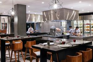 a restaurant with people preparing food in a kitchen at Renaissance Bali Uluwatu Resort & Spa in Uluwatu
