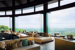 a restaurant with large windows and couches and tables at Renaissance Bali Uluwatu Resort & Spa in Uluwatu