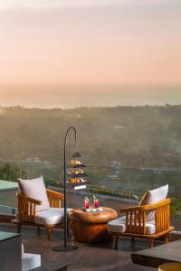 a balcony with two chairs and a table with candles at Renaissance Bali Uluwatu Resort & Spa in Uluwatu
