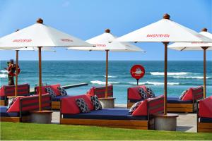 a group of chairs and umbrellas on the beach at Renaissance Bali Uluwatu Resort & Spa in Uluwatu