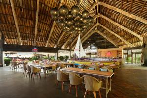 a restaurant with tables and chairs and a large ceiling at Renaissance Bali Uluwatu Resort & Spa in Uluwatu