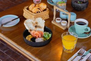 a table with a bowl of food and a basket of bread at Amnaya Resort Kuta in Kuta
