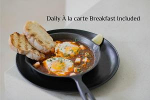 a frying pan with eggs and bread in a bowl at Amnaya Resort Kuta in Kuta