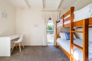 a bedroom with two bunk beds and a desk at Port Philip Panorama - Bayview Retreat and Pool Bliss in Mount Martha +25 photos