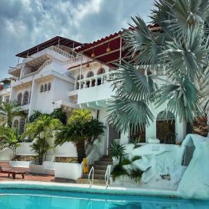 ein Hotel mit einem Swimmingpool vor einem Gebäude in der Unterkunft Calle11 hostal in Rodadero