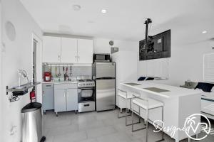 a kitchen with stainless steel appliances and white cabinets at UnitA SeaI Private Studio near Deerfield Beach in Deerfield Beach