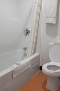 Un baño blanco con inodoro y ducha. en Northern Rockies Lodge, en Muncho Lake 30 fotos más