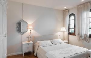 une chambre blanche avec un lit et un miroir dans l'établissement Apt Braida, à Corona