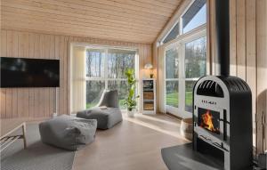 a living room with a fireplace and a tv at Holiday Home Fiskervej In Dnmkt in Skovby