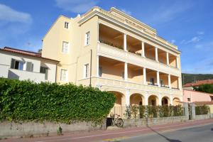 a large white building on the side of a street at La Liberty in Marciana Marina