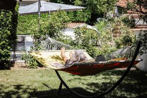 een persoon in een hangmat in een tuin bij La Bohème - VILLA PAULA in Istres