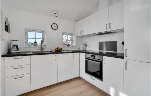 Una cocina con gabinetes blancos y encimeras negras. en Holiday Home Anker Eskildsensvej Hvide Sande Denm, en Nørre Lyngvig