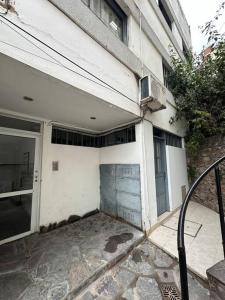 Un edificio blanco con una puerta al costado. en Departamento amoblado en Jujuy, en San Salvador de Jujuy