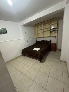 Un dormitorio con una cama y suelo de baldosas. en Departamento amoblado en Jujuy, en San Salvador de Jujuy