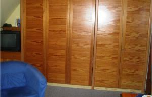 a wooden cabinet in a room with a blue chair at 1 Bedroom Amazing Apartment In Hohwacht in Hohwacht +11 photos