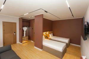a hotel room with two beds and a television at Sansar Hotel in Erdenet