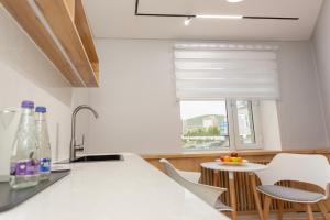 a kitchen with a window and a table with chairs at Sansar Hotel Erdenet in Erdenet