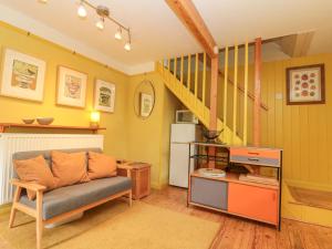 a living room with a couch and a staircase at The Hayloft in Scarborough