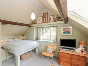 a bedroom with a bed and a flat screen tv at The Hayloft in Scarborough