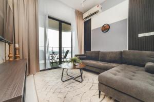 una sala de estar con un sofá y una mesa en Bay Laurel Luxe HighFloor 2BR 4Pax Seaview by Our Stay, en Johor Bahru