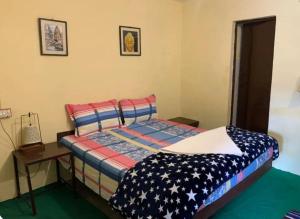 a bedroom with a bed and a nightstand and sidx sidx sidx sidx at The Kashi Baba Homestay in Dharamshala