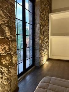 a bedroom with a large stone wall and a large window at Casa Santiago - Zona Exclusiva in Guanajuato