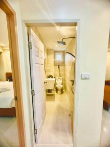 a bathroom with a toilet and a bed in a room at ABC HA Hotel Bangkok in Bangkok