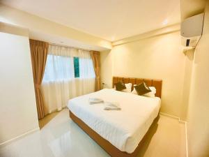 a bedroom with a large white bed with a window at ABC HA Hotel Bangkok in Bangkok +24 photos