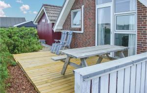 a wooden deck with a picnic table and a chair at Holiday Home Ringkøbing With Fireplace Ii in Ringkøbing +21 photos