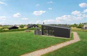 a house with a black facade on a green lawn at Holiday Home Pilemose Ii in Skovby +13 photos