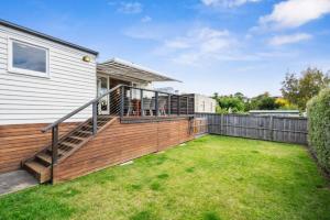 a large backyard with a deck and a house at Stunning newly renovated home in perfect location in Hobart