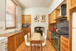 a kitchen with a wooden table and a table and chairs at Whites Corner in Bothwell