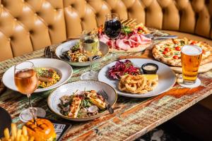 a table with plates of food and glasses of beer at Holiday Inn Warwick Farm by IHG in Warwick Farm