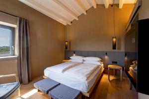 a bedroom with a large bed and a window at Rara Factory Design House in Orvieto