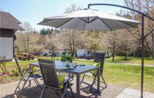 ThalfangにあるFerienhaus 20 In Thalfangのパティオ(パラソルの下にテーブルと椅子付)