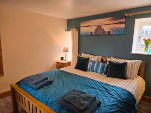 a bedroom with a bed with towels on it at Barcud Cottage in Carmarthen