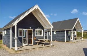 a blue house with a picnic table in front of it at Hytte 11 in Thyborøn +19 photos