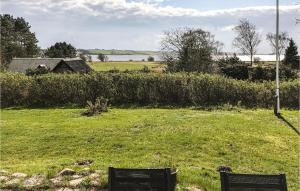 two benches sitting in a field of grass at Holiday Home Strandholmen Millinge V in Millinge