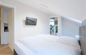 a white bedroom with a large white bed in it at Baltischer Hof Apartment 67 in Boltenhagen