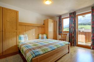 a bedroom with a bed and a large window at Haus Jasmin in Ellmau +8 photos
