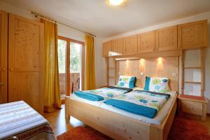 a bedroom with a large bed with blue pillows at Haus Jasmin in Ellmau