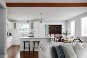 a living room with a couch and a kitchen at Austin Cottage - Pet friendly! in Merewether