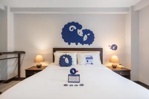 a bedroom with a bed with a blue sheep on the wall at Kokotel Khao Lak Seascape in Khao Lak