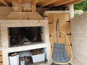 eine Veranda mit einem Schaukelstuhl vor einem Kamin in der Unterkunft Villa Ana in Sevid