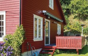 a red house with a bench in front of it at 4 Bedroom Cozy Home In Farsund in Farsund +16 photos